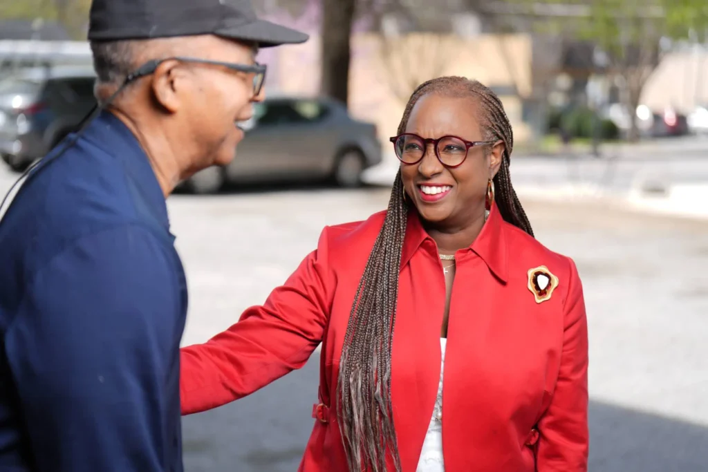 Toni Belin Ingram in red blazer smiling with a civilian